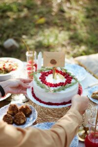 White and Red Cake With Lighted Candles on Table